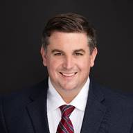 A person wearing a suit and tie
Description automatically generated